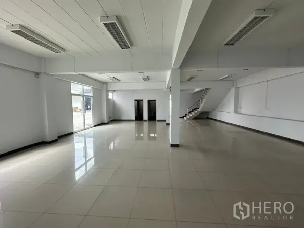 Warehouse for rent in Phra Nakhon Si Ayutthaya - Open-plan ground floor office or showroom with wide windows and stair access.
