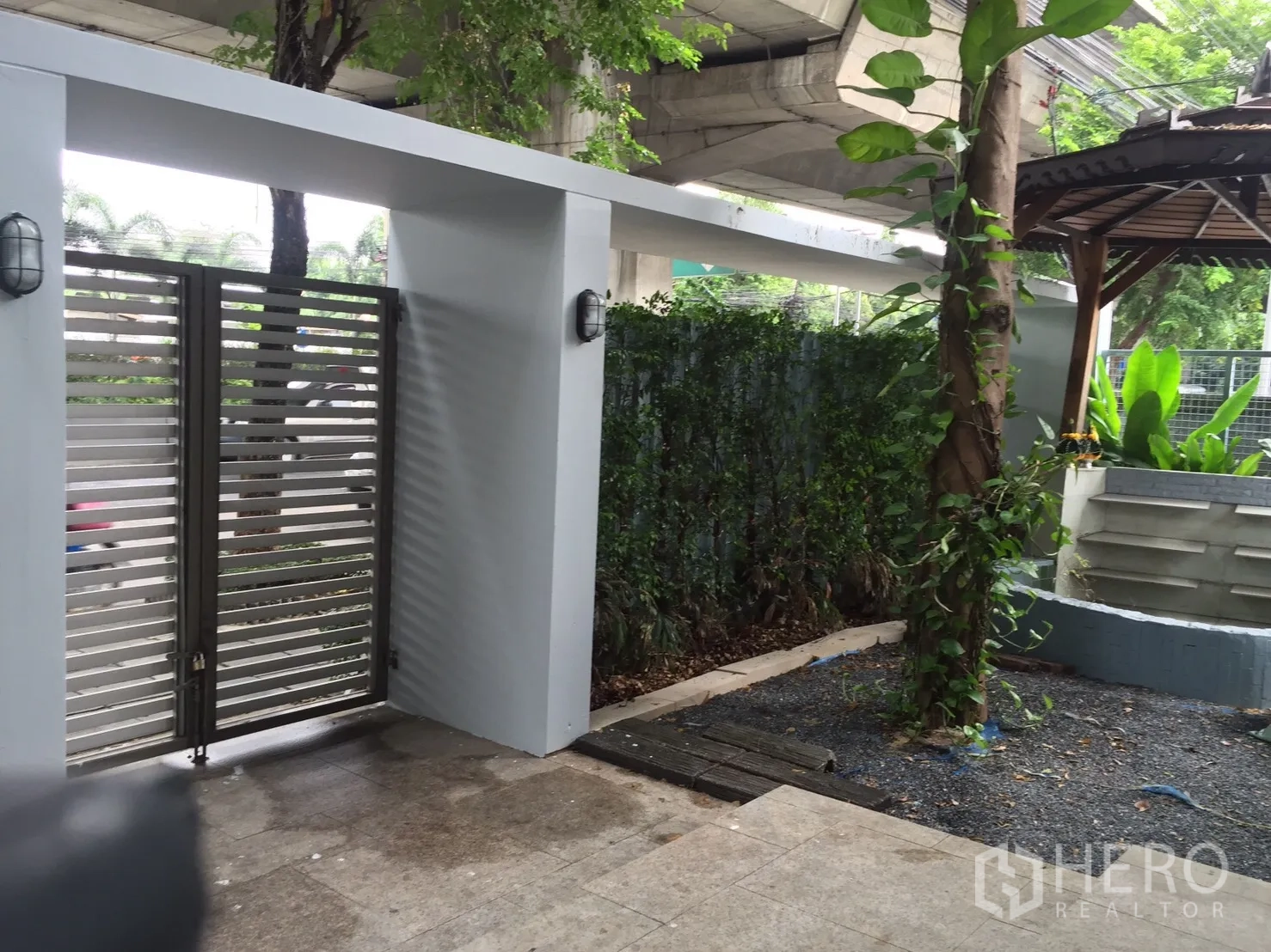 Home Office for rent or sale in Suan Luang, Bangkok - Gated garden entrance with a small pavilion, hedges, and climbing plants.