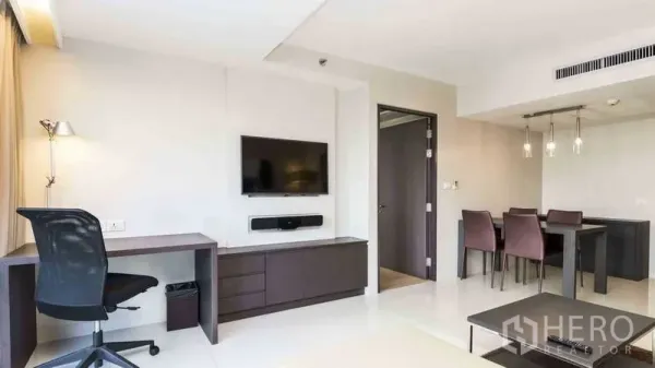 房间 出租在Watthana, Bangkok - 客厅与餐区一体，墙挂电视、内置书桌与吊灯餐桌。