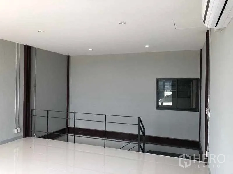 Warehouse for rent in Bang Phli, Samut Prakan - Mezzanine landing with AC unit and recessed lights overlooking the warehouse.