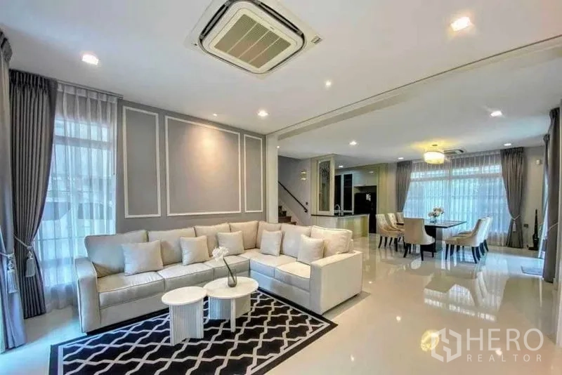 独立式住宅 出租在Bang Khen, Bangkok - 开放式客餐厅，L形沙发与落地窗。