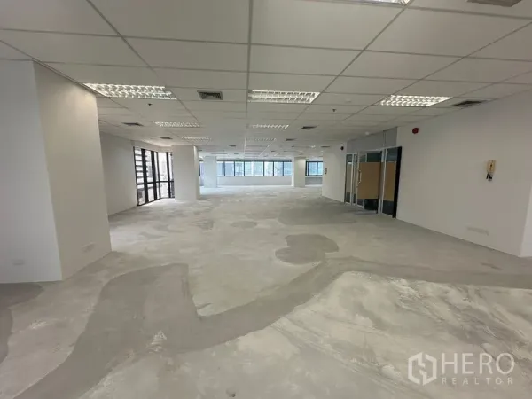 Office Space for rent in Bang Rak, Bangkok - Spacious open workspace showing glass-partition entrance and multiple window lines.