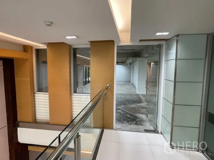 办公空间 出租在Ratchathewi, Bangkok - 楼道配不锈钢扶手与玻璃门，通往办公套间。