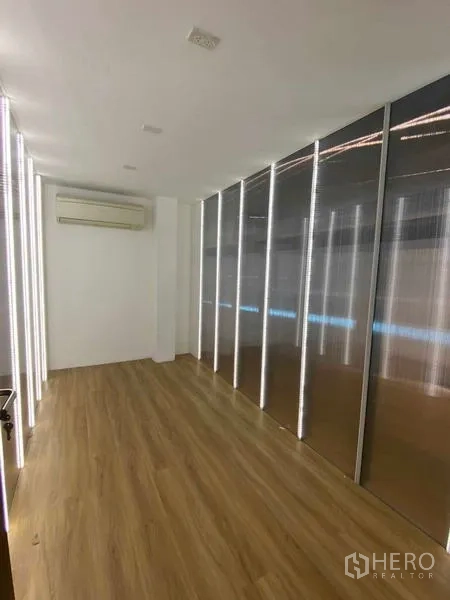 Home Office for rent in Wang Thonglang, Bangkok - Narrow room with LED-lit wall panels, wood flooring and air conditioning