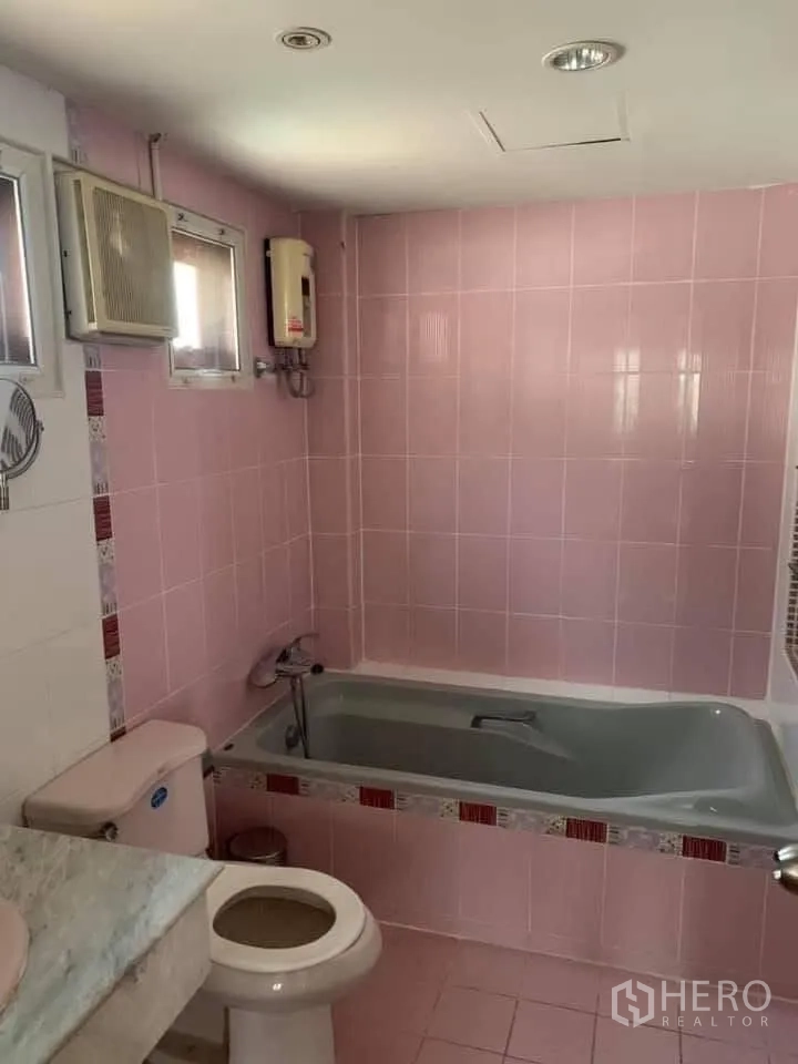 Townhouse for rent in Watthana, Bangkok - Pink-tiled bathroom with bathtub, toilet and water heater.