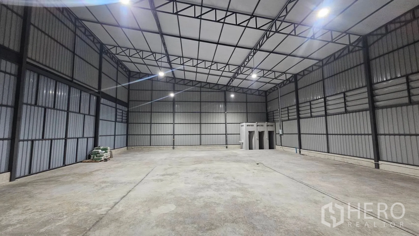 Warehouse for rent in Bang Khen, Bangkok - Spacious warehouse hall with bright overhead lighting and a concrete floor.
