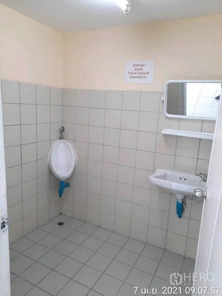 工厂 出租在Bang Bua Thong, Nonthaburi - 整洁的卫浴空间，墙地砖、挂式小便器、洗手盆与镜子。