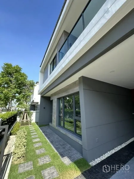 Detached House for rent in Bang Phli, Samut Prakan - Front side walkway bordered by lawn and large ground-floor windows.