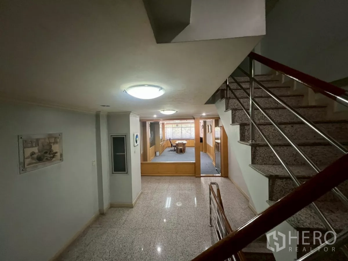 Shophouse for rent in Bang Rak, Bangkok - Stair landing leading to a glass-partitioned office or meeting room.