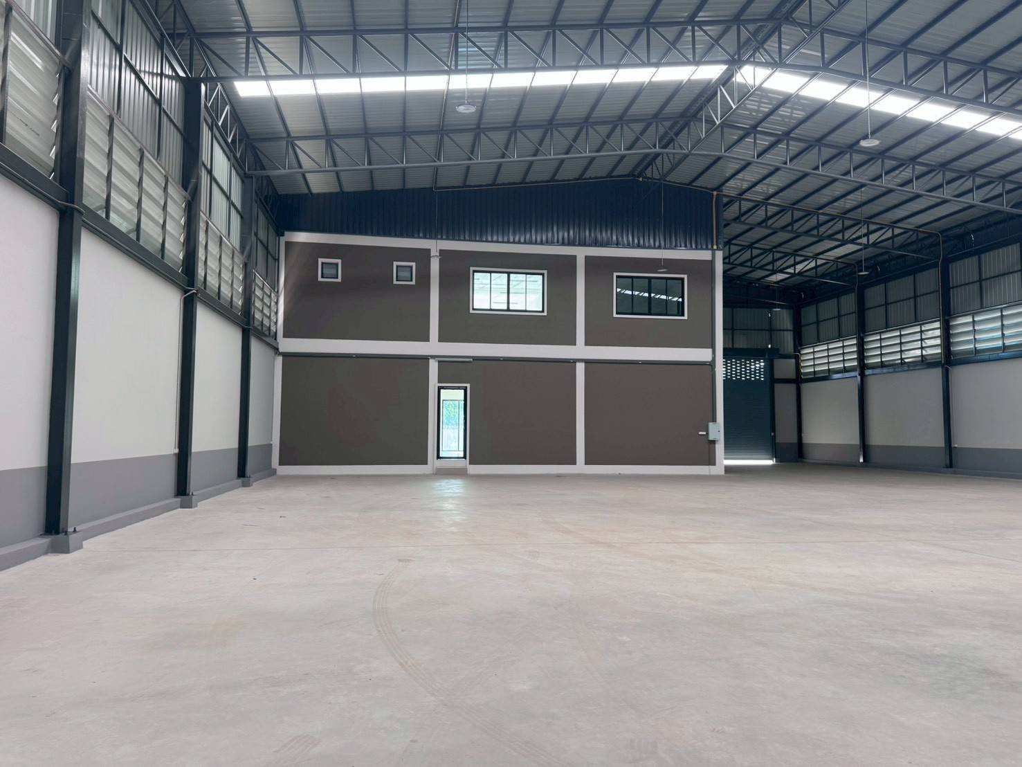Factory for sale in Mueang Samut Sakhon, Samut Sakhon - Spacious factory hall featuring high steel truss roof, ventilation louvers and internal office block.