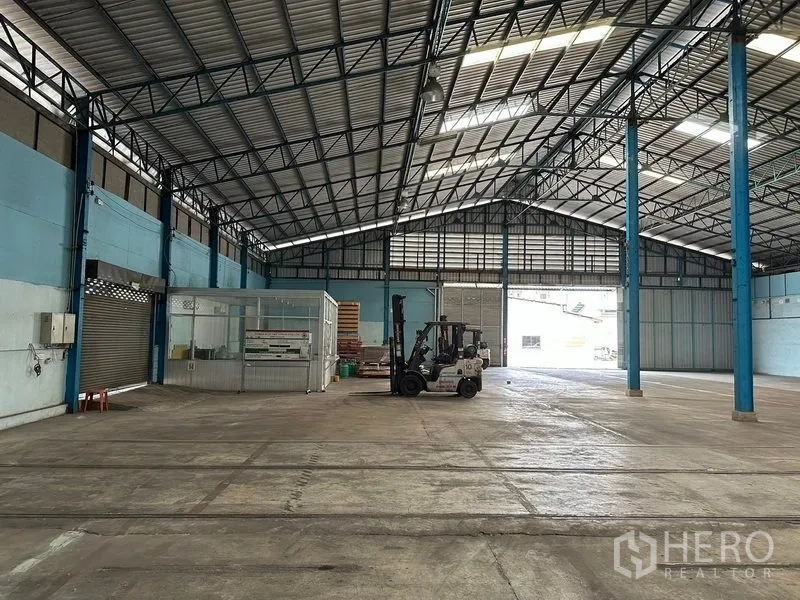 Warehouse for rent in Bang Pa-in, Phra Nakhon Si Ayutthaya - Interior area with a forklift beside a small glass office and roller shutter door.