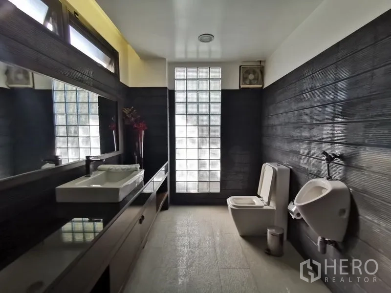 带办公室的家 出售在Wang Thonglang, Bangkok - 现代卫生间，长台面方形洗手盆、坐厕与小便斗，玻璃砖采光。
