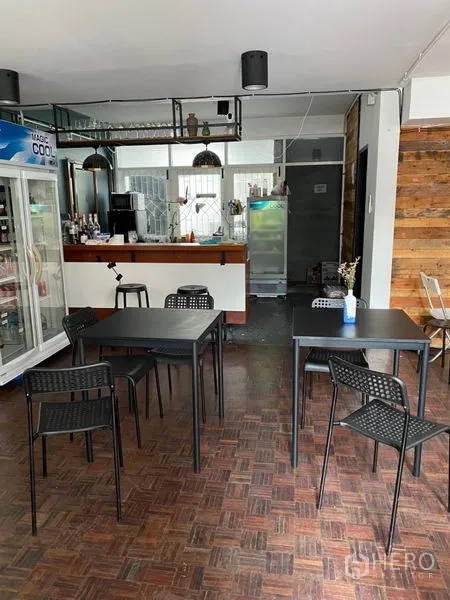Home Office for rent in Pathum Wan, Bangkok - Cafe-style bar with hanging lights, glassware rack and black dining tables in front.