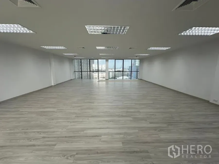 办公空间 出租 - 大开间工作区，均匀天花灯光与落地窗，面向城市景色
