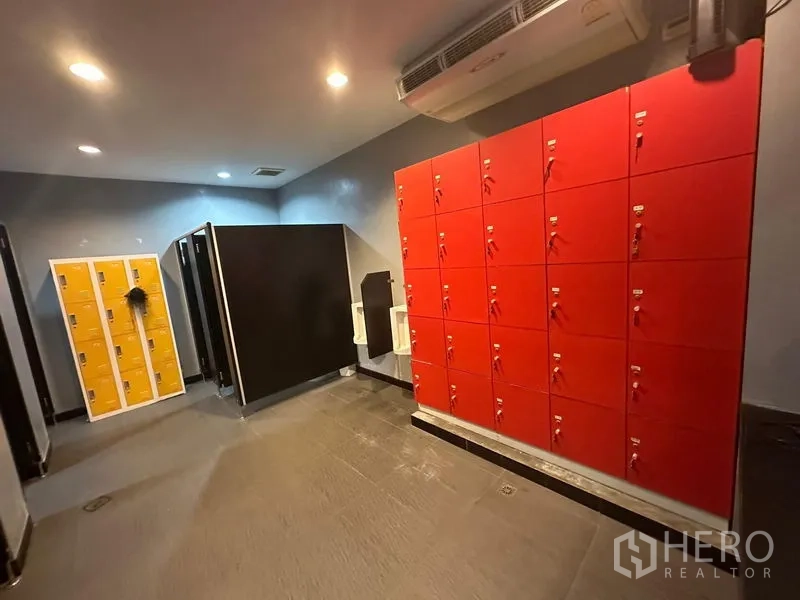 Warehouse for rent in Khlong Toei, Bangkok - Locker room with bright red lockers, tiled floor and ceiling lights.