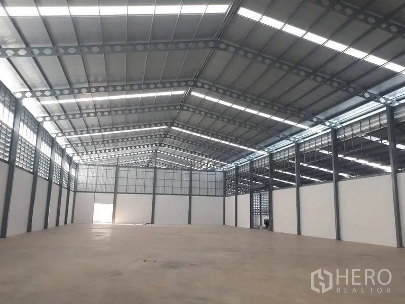 货栈 出租在Bang Phli, Samut Prakan - 宽敞高挑的仓库内部，钢结构桁架屋顶、天窗与抛光混凝土地面。