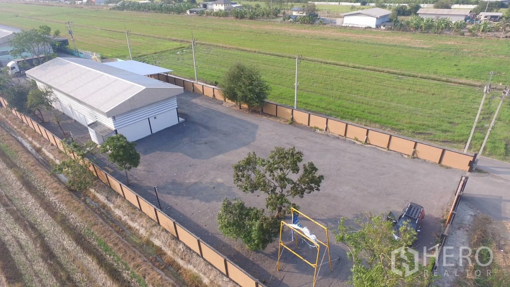 Warehouse for sale in Lam Luk Ka, Pathum Thani - Aerial view of warehouse within fenced compound and open hardstand yard.