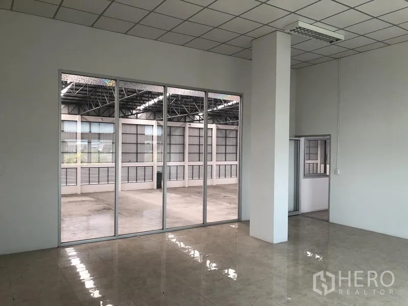 Factory for rent in Phra Nakhon Si Ayutthaya - Bright tiled office room with large glass wall facing the warehouse.