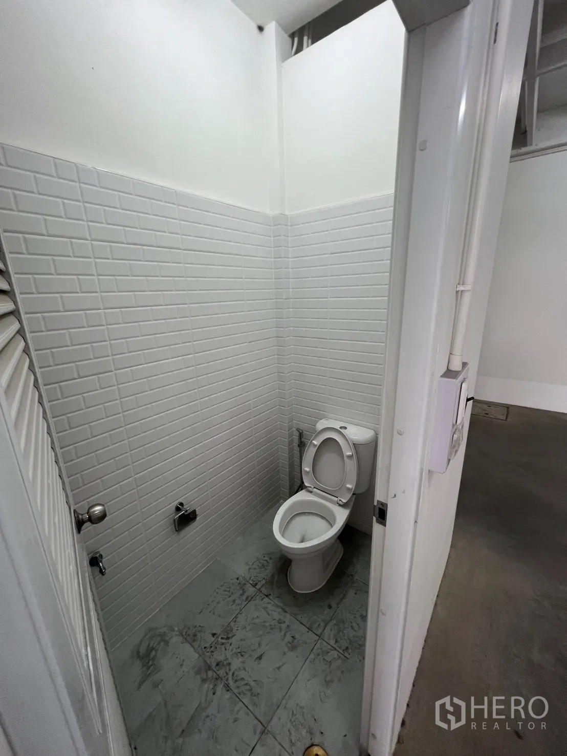 Shophouse for rent in Khlong Toei, Bangkok - Refreshed restroom with white subway tiles and ceramic toilet.