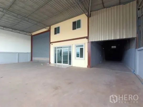 Factory for rent or sale in Mueang Samut Sakhon, Samut Sakhon - Warehouse facade showing glass-front office, roller door and sheltered yard.