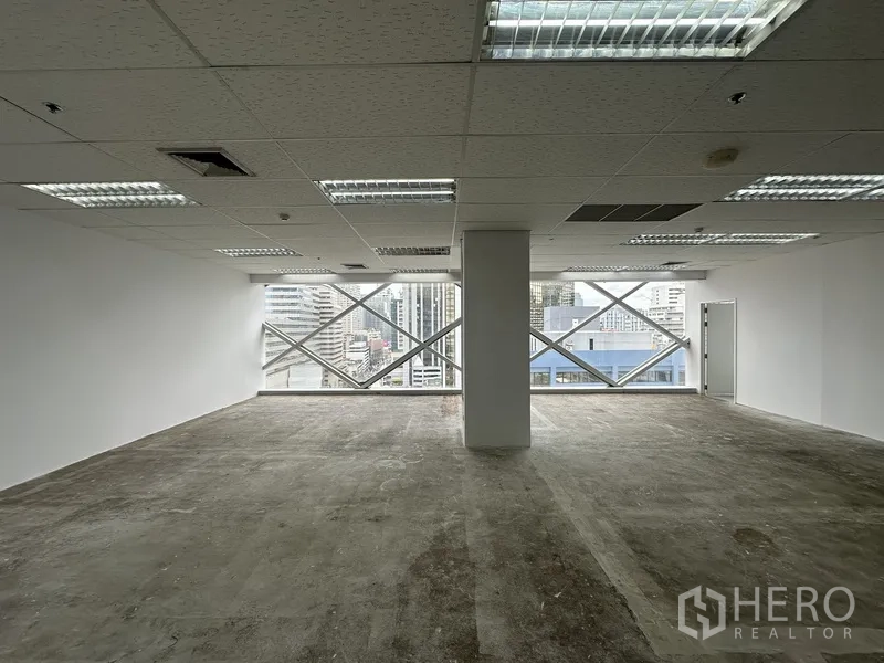 Office Space for rent in Watthana, Bangkok - Open-plan office with large diagonal-framed windows and city views.