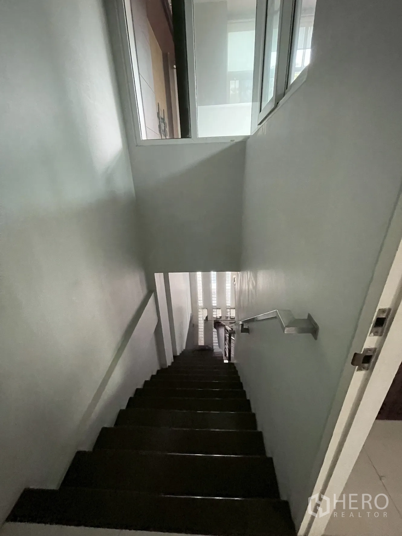 Home Office for rent in Wang Thonglang, Bangkok - Stairwell with dark wood steps, handrail and high windows for natural light.