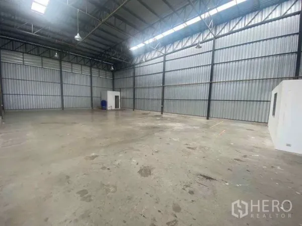 Warehouse for rent in Bang Phli, Samut Prakan - Large clear-span warehouse bay with bright skylight panels and side partition rooms.