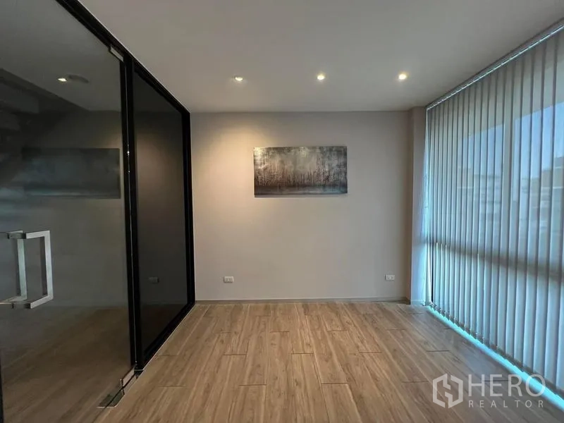 Home Office for rent in Bueng Kum, Bangkok - Bright office nook with glass partition, blinds and recessed lighting.