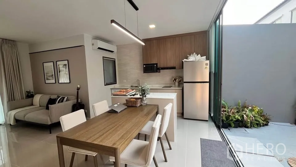 Townhouse for rent or sale in Bang Phli, Samut Prakan - Kitchen island and dining area connecting to living room and stairs.