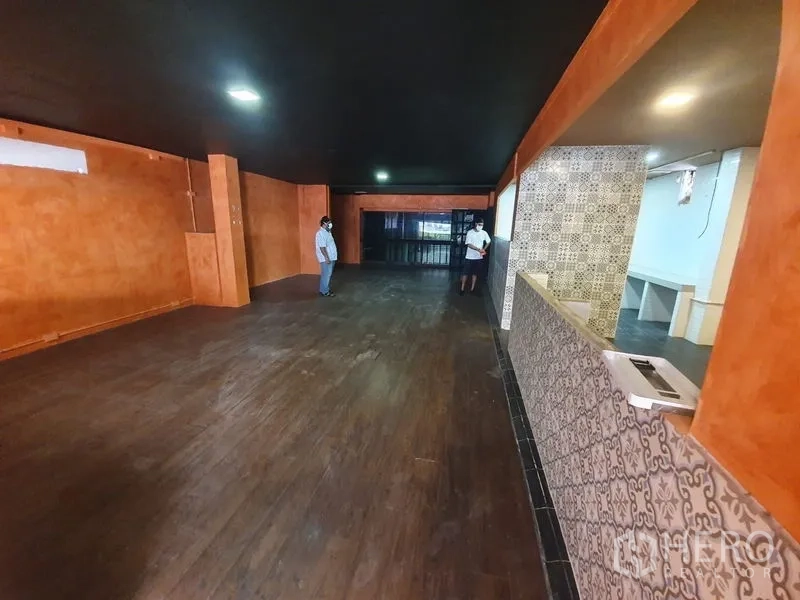 店屋 出租在Khlong Toei, Bangkok - 一层长形大厅，深色天花、木地板与服务吧台。