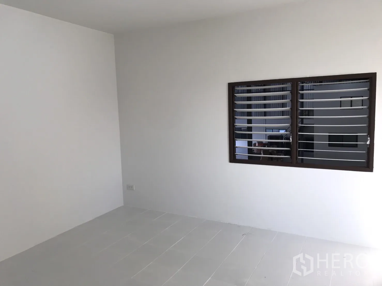 Warehouse for rent in Lam Luk Ka, Pathum Thani - Compact office room with louvered window facing the warehouse.