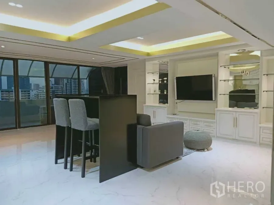 Condominium for  in Watthana, Bangkok - Living room with bar counter, built-ins and curved glass balcony enclosure.