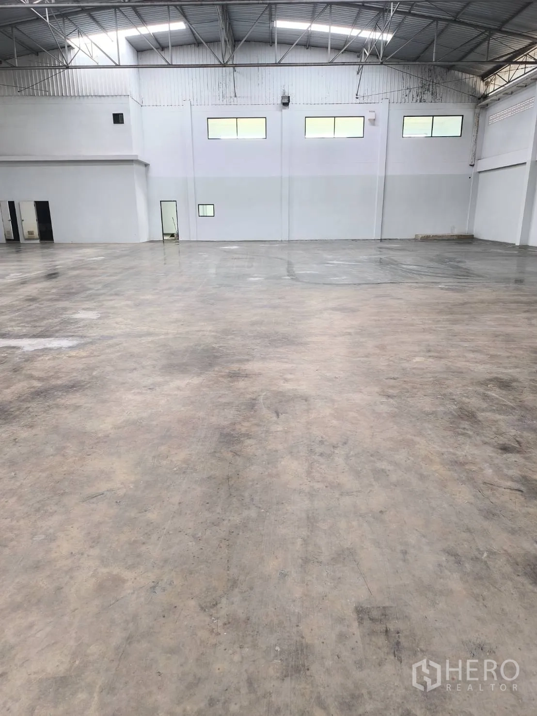 工厂 for sale in Khlong Luang, Pathum Thani - 开阔仓库，抛光混凝土地面与办公室区。