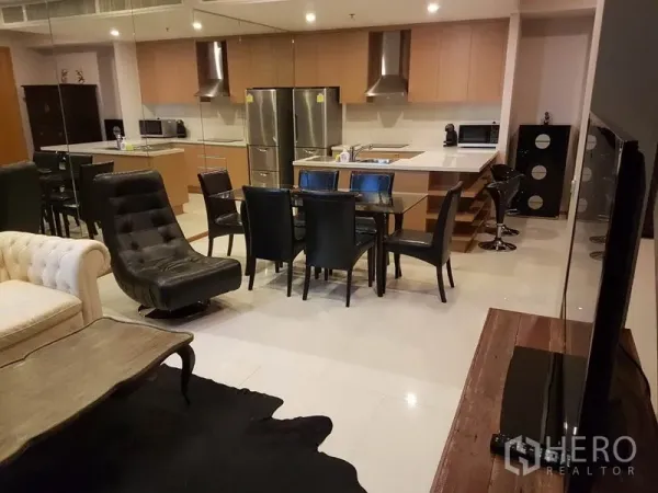 Condominium for rent or sale in Khlong Toei, Bangkok - Open-plan living and dining with sleek island kitchen and stainless fridge in a duplex condo.