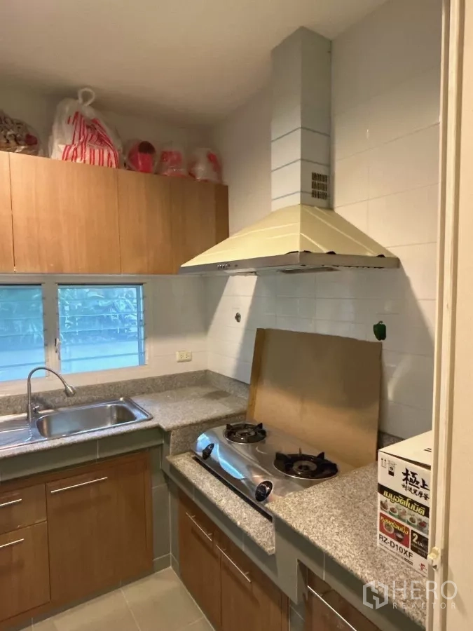 Detached House for sale in Bang Kapi, Bangkok - Thai kitchen corner with gas hob, extractor hood, and ample countertop space.