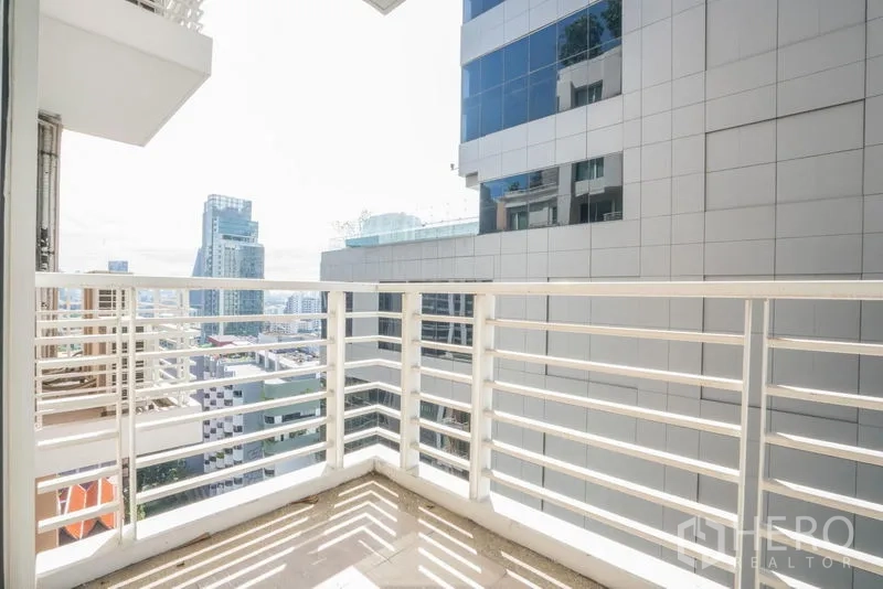 Condominium for rent or sale in Khlong Toei, Bangkok - Sunny balcony with white railing and city skyline views.