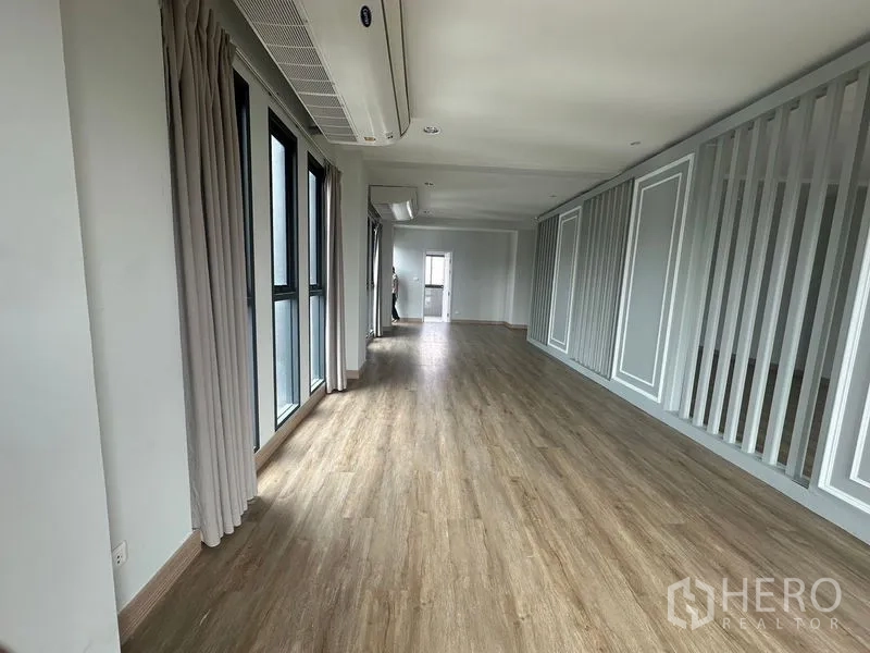 Home Office for rent in Suan Luang, Bangkok - Long workspace with full-height windows, curtains, and decorative slat wall.