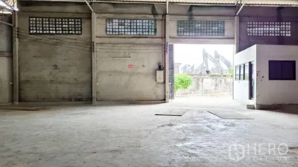 Warehouse for rent in Mueang Samut Sakhon, Samut Sakhon - Spacious warehouse interior with high ceiling, concrete floor and loading opening to the front.