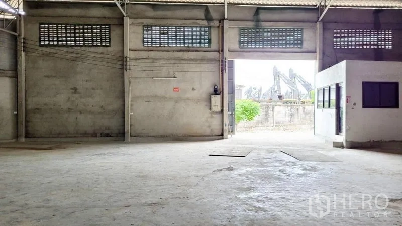 Warehouse for rent in Mueang Samut Sakhon, Samut Sakhon - Spacious warehouse interior with high ceiling, concrete floor and loading opening to the front.