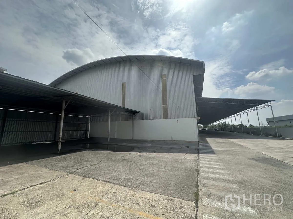 Warehouse for rent in Bang Pa-in, Phra Nakhon Si Ayutthaya - Side view of warehouse showing wide canopy-covered loading area and drive-through apron.