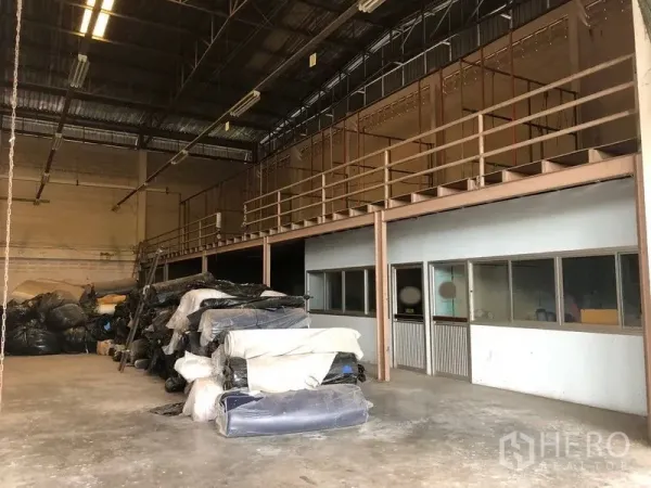 Factory for sale in Lam Luk Ka, Pathum Thani - Warehouse mezzanine with safety railings and ground-floor office windows beneath.