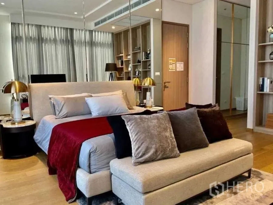 Condominium for sale - Spacious master bedroom with upholstered bed, bench, twin bedside tables and mirrored wall.