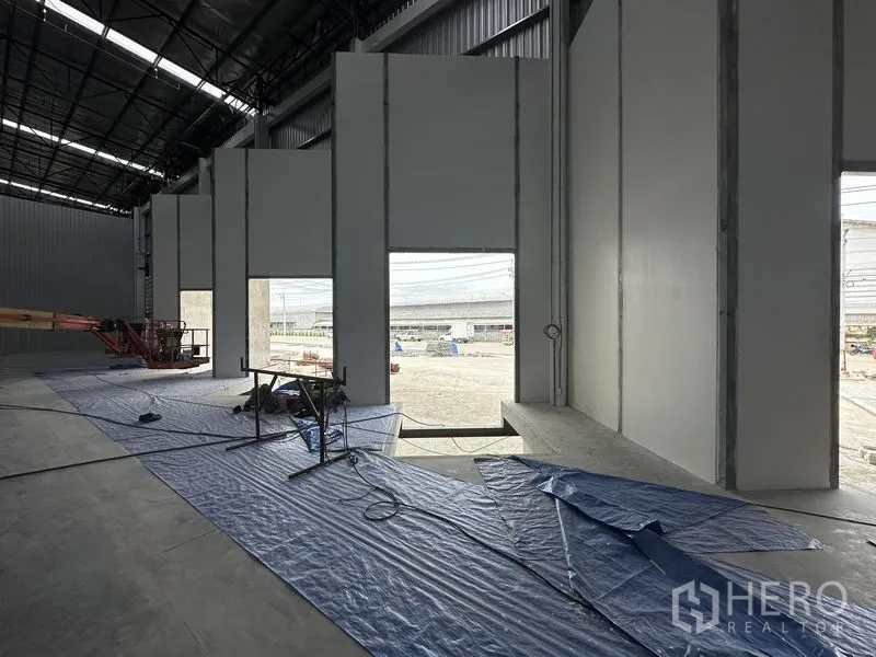 Factory for rent in Khlong Luang, Pathum Thani - Warehouse interior showing tall openings to the yard and insulated wall panels.