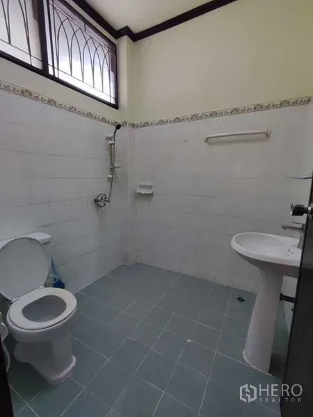บ้าน ให้เช่าในKhlong Toei, Bangkok - ห้องน้ำปูกระเบื้อง พร้อมโถสุขภัณฑ์ ฝักบัว และอ่างล้างหน้า ใต้หน้าต่างสูง