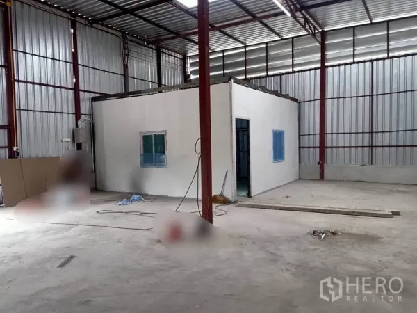 Warehouse for rent in Mueang Samut Sakhon, Samut Sakhon - Built-in office room inside the warehouse with window and doorway beside steel wall panels.