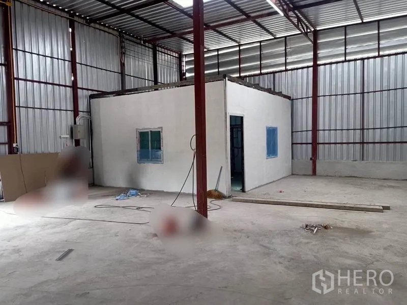 Warehouse for rent in Mueang Samut Sakhon, Samut Sakhon - Built-in office room inside the warehouse with window and doorway beside steel wall panels.