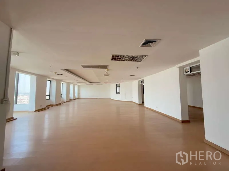 Office Space for rent in Chatuchak, Bangkok - Panoramic open-plan office with rows of windows and a central ceiling soffit.