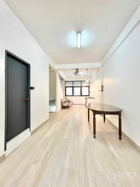 Home Office for rent in Khlong Toei, Bangkok - Long corridor-style room with table, neutral tones and stair access.