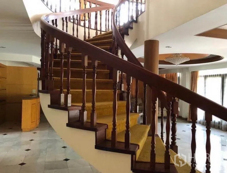 Detached House for sale in Mueang Samut Prakan, Samut Prakan - Grand curved wooden staircase with carpet runner in the foyer.