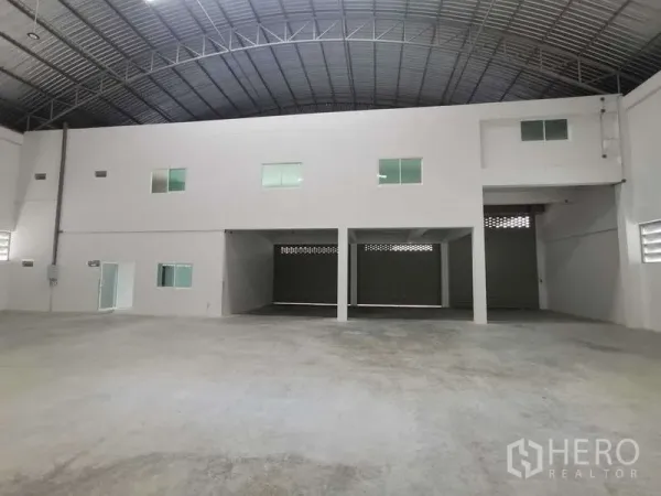 Factory for rent or sale in Bang Bo, Samut Prakan - Entrance bay with mezzanine offices above and several roller doors for loading.